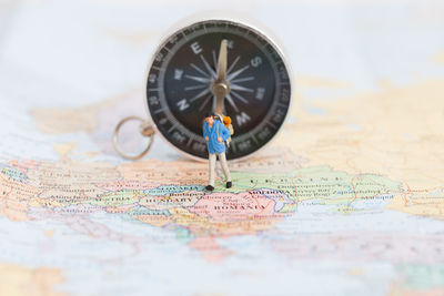 Close-up of figurine and compass on map