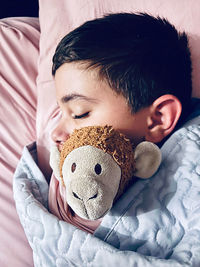 Close-up of cute boy sleeping on bed at home