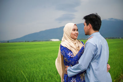 Portrait of a muslim asian couple husband and wife posing happily at paddy field.