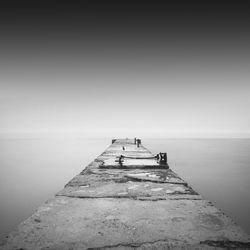 Pier amidst sea against sky during foggy weather