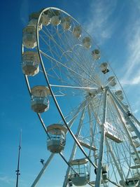 Low angle view of ferris wheel against blue sky