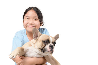 Portrait of cute girl with dog against white background