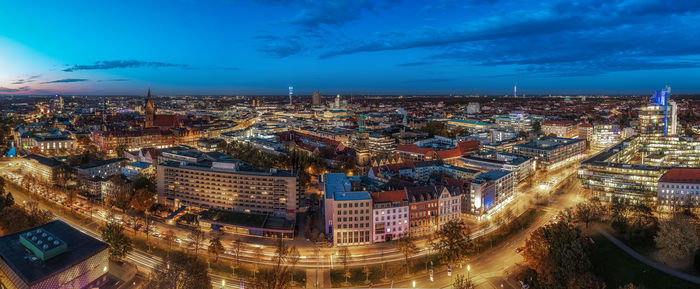 High angle view of illuminated buildings against sky at night