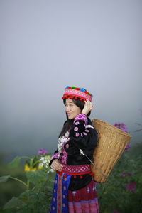 Woman wearing hat standing against basket