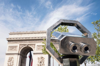 Low angle view of arc de triomphe against cloudy sky