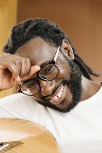 Close-up of smiling man wearing eyeglasses with guitar