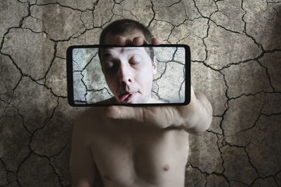 Portrait of shirtless man using mobile phone