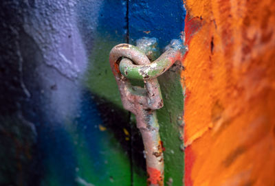 Close-up of rusty metal chain against wall