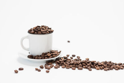 Coffee beans on table against white background