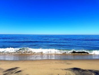 Scenic view of sea against clear blue sky