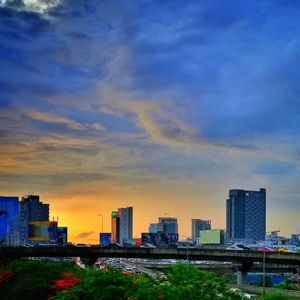 Skyscrapers in city at sunset