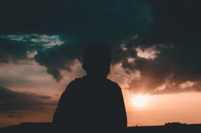 Silhouette man standing against sky during sunset