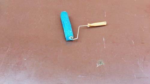 High angle view of blue paint roller on floor