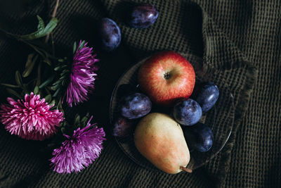 Apples and plums on the table