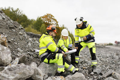 Engineers in reflective clothing looking at plans