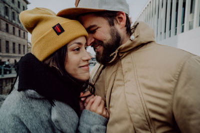 Young couple kissing in park during winter