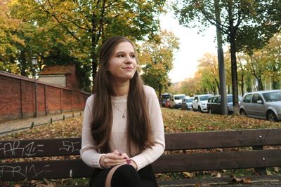 Portrait of beautiful young woman sitting outdoors