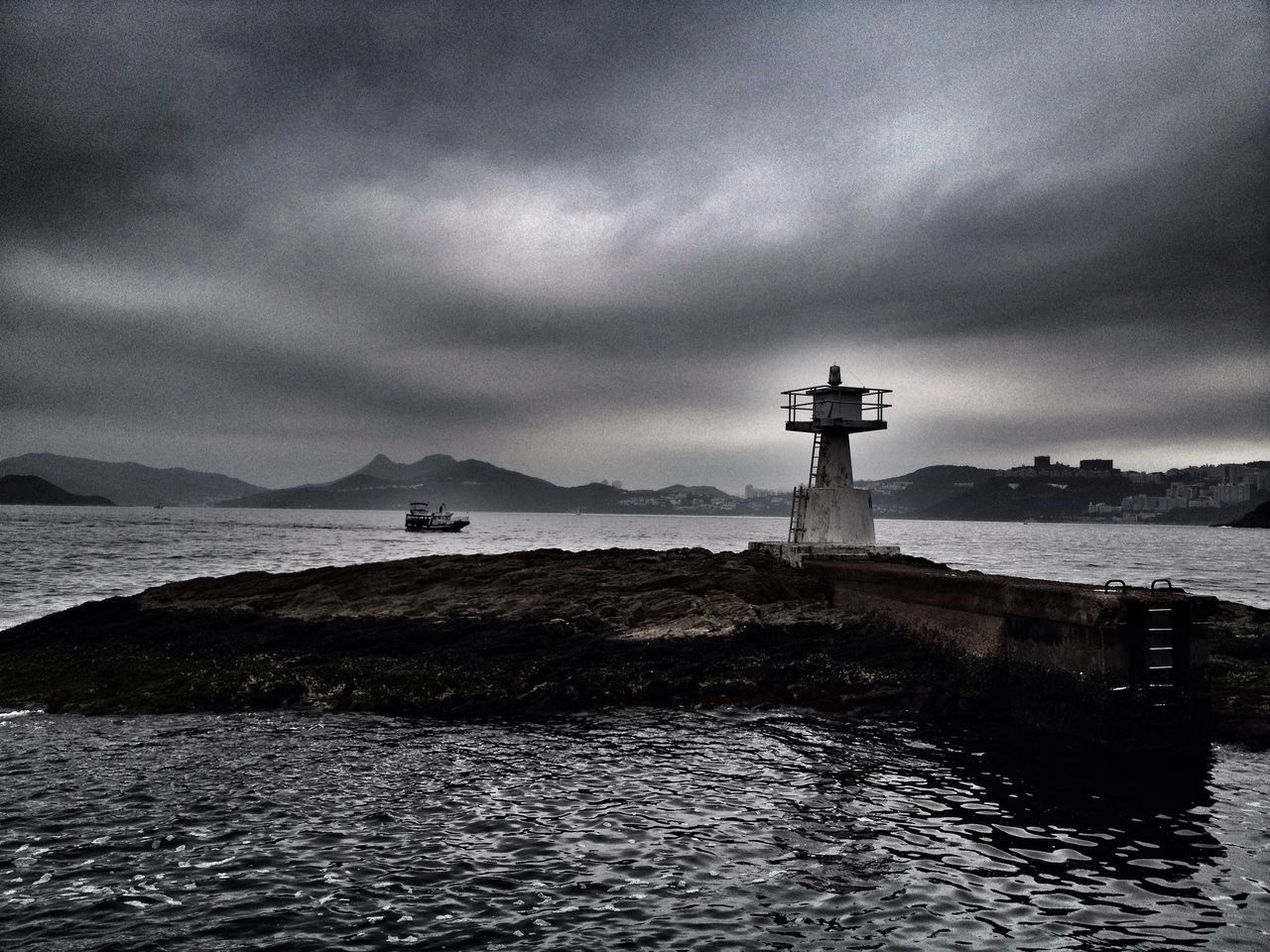 water, sea, sky, lighthouse, cloud - sky, cloudy, built structure, waterfront, tranquility, architecture, tranquil scene, building exterior, scenics, weather, guidance, nature, overcast, beauty in nature, horizon over water, cloud