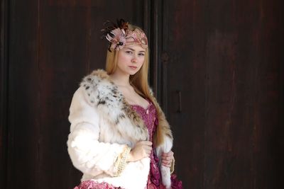 Portrait of beautiful young woman wearing fur coat during carnival