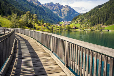 Footbridge over lake against mountains