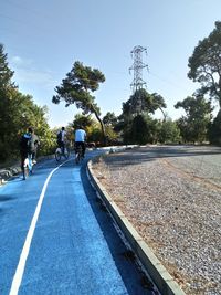 Rear view of people riding motorcycle on road