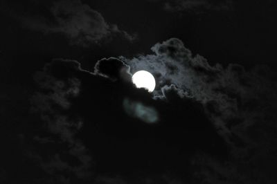 Low angle view of moon in cloudy sky
