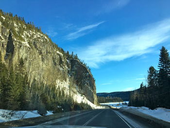 Road amidst snowcapped mountains against sky