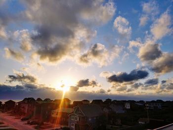 Houses in town against sky during sunset