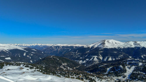 Scenic view of snowcapped mountains against blue sky