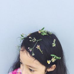 Close-up of girl with flowers against wall