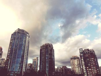 Low angle view of apartment buildings against cloudy sky