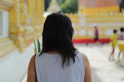 Rear view of woman standing at temple