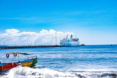 Ship sailing in sea against blue sky