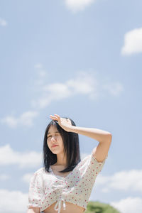 Beautiful young woman against sky