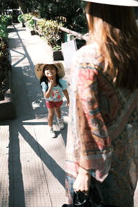 Midsection of mother photographing daughter