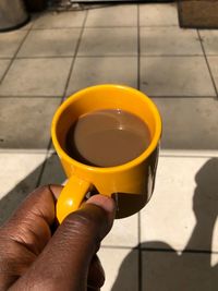 High angle view of hand holding coffee cup
