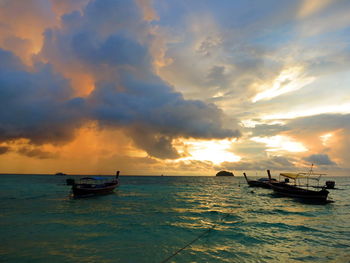 Boat in sea against sunset sky