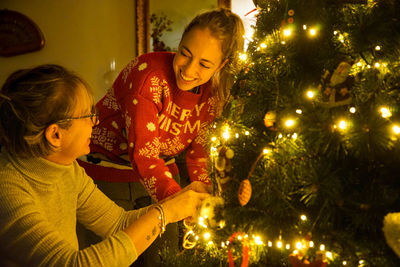 Rear view of woman with illuminated christmas tree