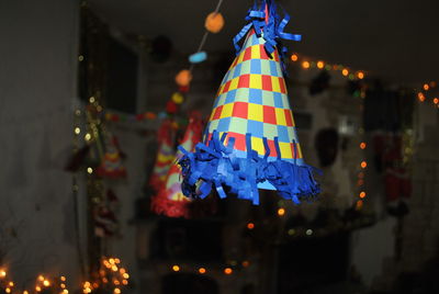 Illuminated christmas decorations hanging on tree at night