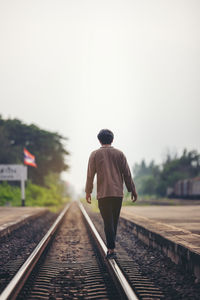 Man walk away on railroad with warm light. selective focus. traveler man on railroad. person