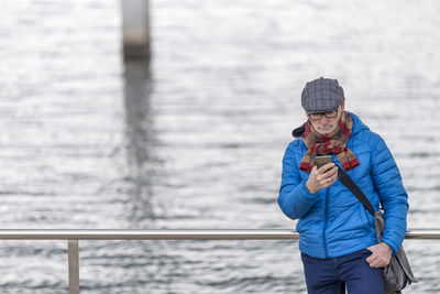 Side view of couple standing on railing