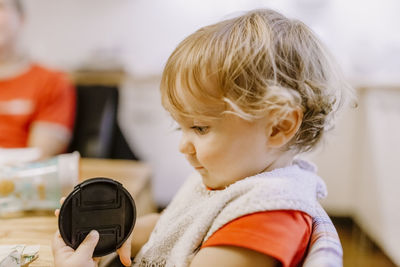 Close-up of girl holding lid at table