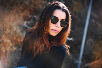 Portrait of young woman wearing sunglasses standing outdoors