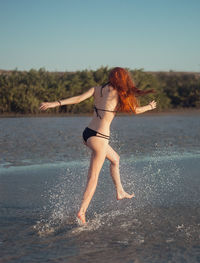 Full length of woman on beach against clear sky