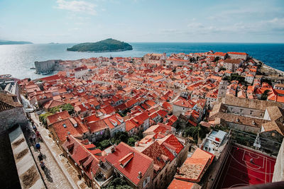 High angle view of townscape by sea against sky