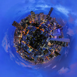 Aerial view of illuminated buildings in city against sky