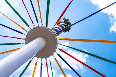 Low angle view of chain swing ride against blue sky