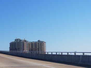 Road against clear blue sky