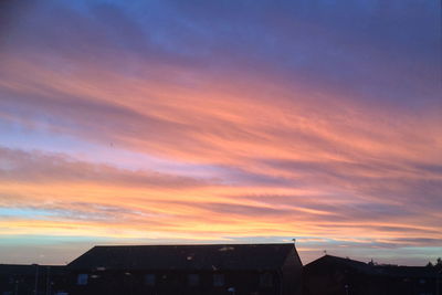 Silhouette cityscape against sky during sunset