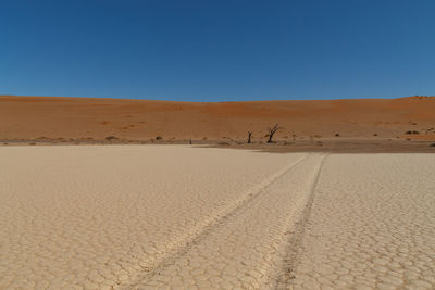 Scenic view of desert against clear blue sky